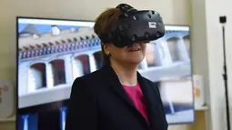 PM Skotlandia Nicola Sturgeon mencoba headset realitas maya selama demonstrasi kemitraan konservasi antara Museum Istana dan Lingkungan Bersejarah Skotlandia, di Kota Terlarang, bekas rumah kaisar Tiongkok, di Beijing (10/4). (AFP Photo/Greg Baker)