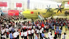Sejumlah pekerja saat mengikuti peluncuran pesawat Amfibi AG600 di Zhuhai, Guangdong, China, (23/7). AG600 merupakan pesawat amfibi terbesar di dunia yang dibangun untuk misi maritim dan memadamkan kebakaran hutan. (AFP PHOTO/STR/Cina OUT)