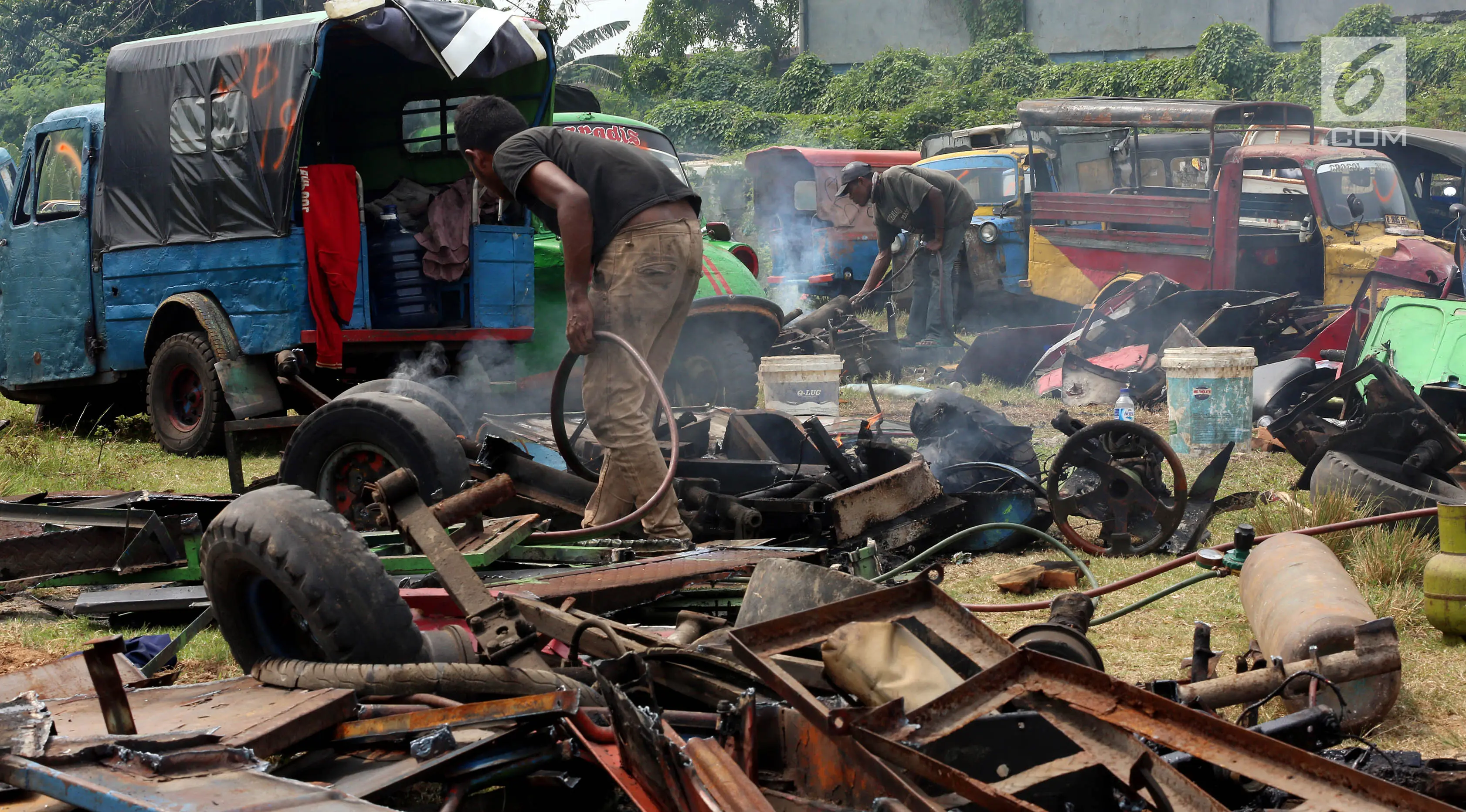 Pekerja memusnahkan bemo hasil razia di sejumlah wilayah di Jakarta, di pool Rawa Buaya, Cengkareng, Jakarta Barat, Selasa (1/8). Pemusnahan dilakukan, dikarenakan sejak 6 Juni 2017, Dishub DKI melarang bemo beroperasi. (Liputan6.com/Johan Tallo)