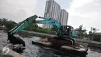 Petugas mengoperasikan eskavator untuk mengeruk lumpur di Kali Sunter Podomoro, Jakarta, Jumat (4/12). Pemprov DKI bersama Kementrian PU melakukan pembebasan bantaran sungai. (Liputan6.com/Gempur M Surya)