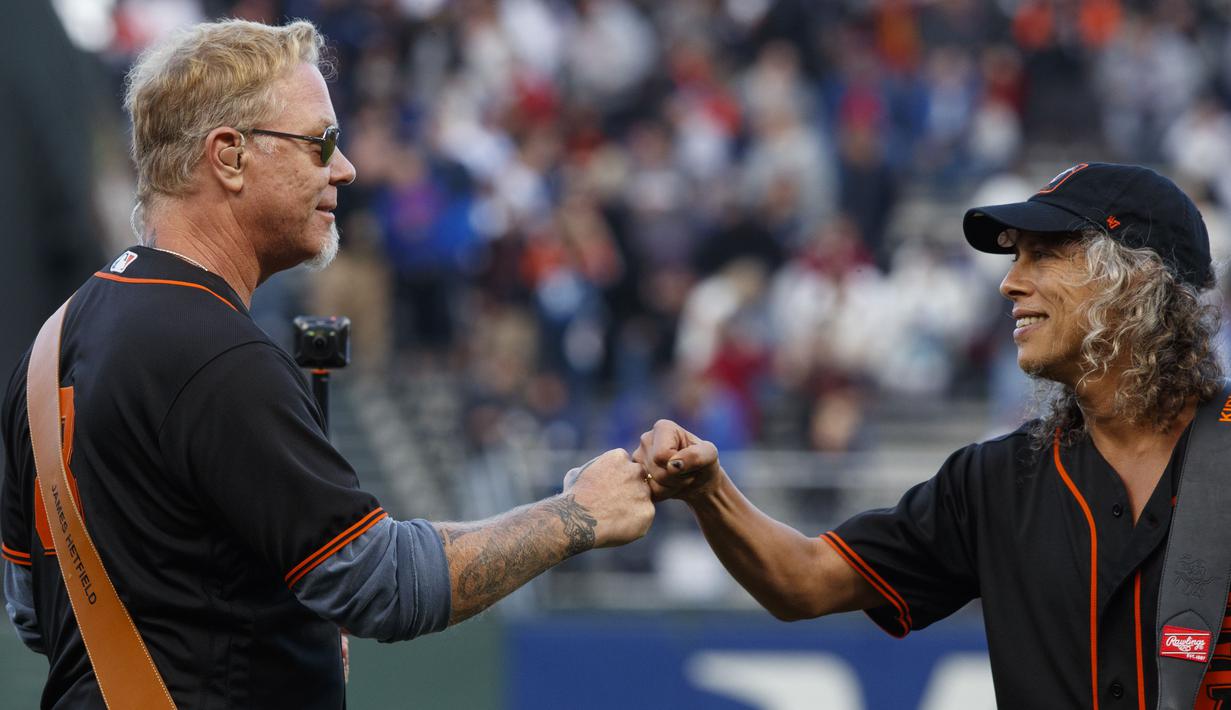 James Hetfield dan Kirk Hammett merayakan keberhasilannya tampil saat membuka laga MLB antara San Francisco Giants melawan Chicago Cubs di AT&T Park, an Francisco, (7/8/2017). San Francisco kalah 3-5 dari Cubs. (Jason O. Watson/Getty Images/AFP)