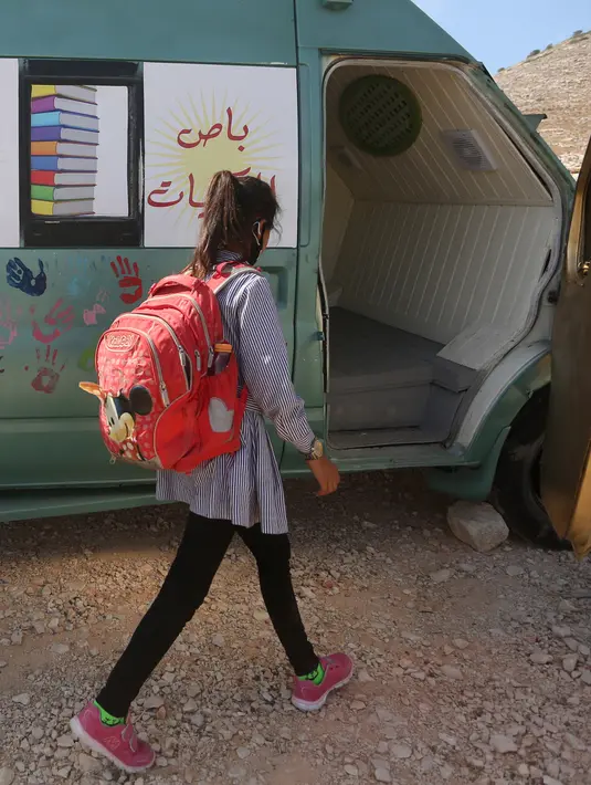 Seorang siswa Palestina berjalan menuju bus yang telah dialihfungsikan menjadi ruang kelas keliling di Khirbet Ibziq, dekat Kota Tubas, Tepi Barat, 8 Oktober 2020. Sebuah asosiasi lokal mengalihfungsikan sebuah bus menjadi perpustakaan dan ruang kelas keliling. (Xinhua/Ayman Nobani)