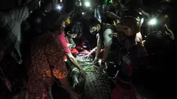 Warga membebaskan seekor buaya dari ban yang tersangkut pada lehernya selama sekitar lima tahun sebelum dilepaskan ke sungai di Palu, Sulawesi Tengah, 7 Februari 2022. Lokasi pelepasan buaya tepat di tempat penangkapannya, di bawah Jembatan II, Kecamatan Palu Selatan. (MUHAMMAD RIFKI/AFP)