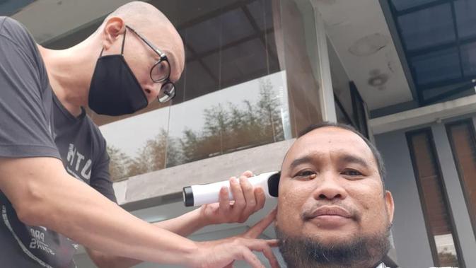 Warga di salah satu perumahan jadi relawan cukur rambut bagi tetangganya di tengah penerapan Pembatasan Sosial Berskala Besar (PSBB) kota Tangerang Selatan, Banten, Sabtu (18/4/2020).  (Marco Tampubolon/Liputan6.com)