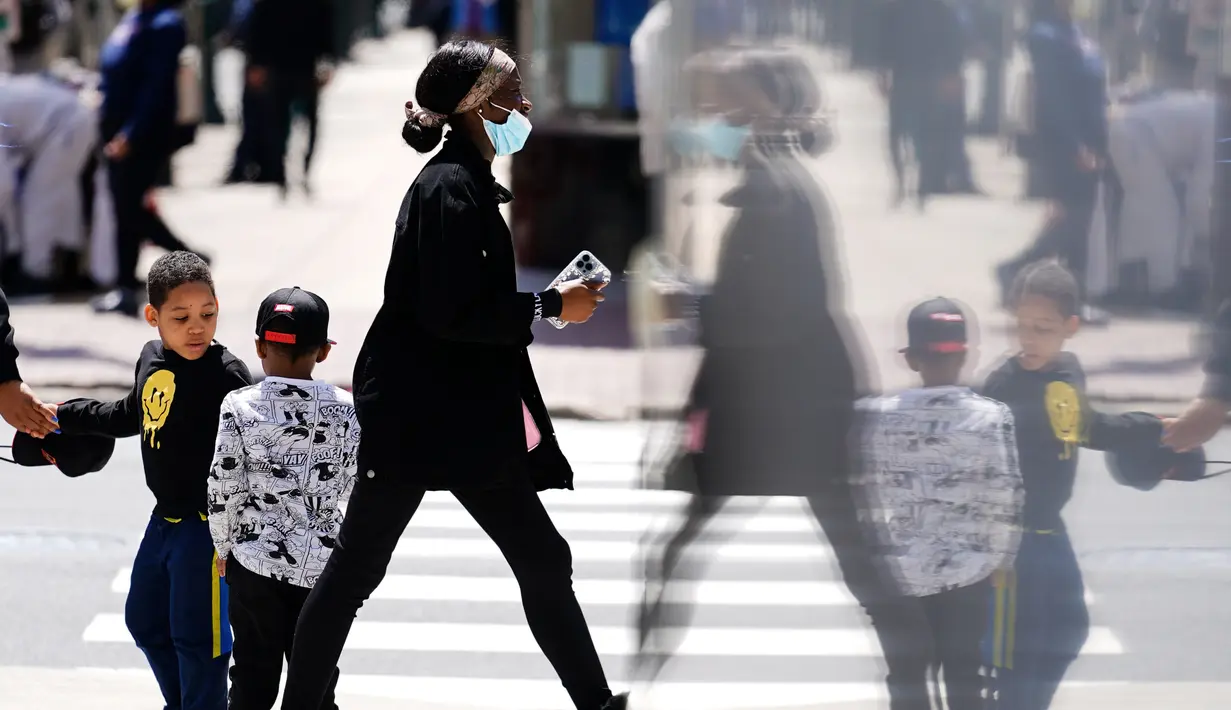 <p>Seorang pejalan kaki yang mengenakan masker berjalan di Philadelphia, Jumat (22/4/2022). Kota itu meninggalkan mandat masker dalam ruangan pada hari Jumat, hanya beberapa hari setelah menjadi kota metropolitan AS pertama yang menerapkan kembali wajib masker sebagai tanggapan atas peningkatan kasus COVID-19 dan rawat inap. (AP Photo/Matt Rourke)</p>