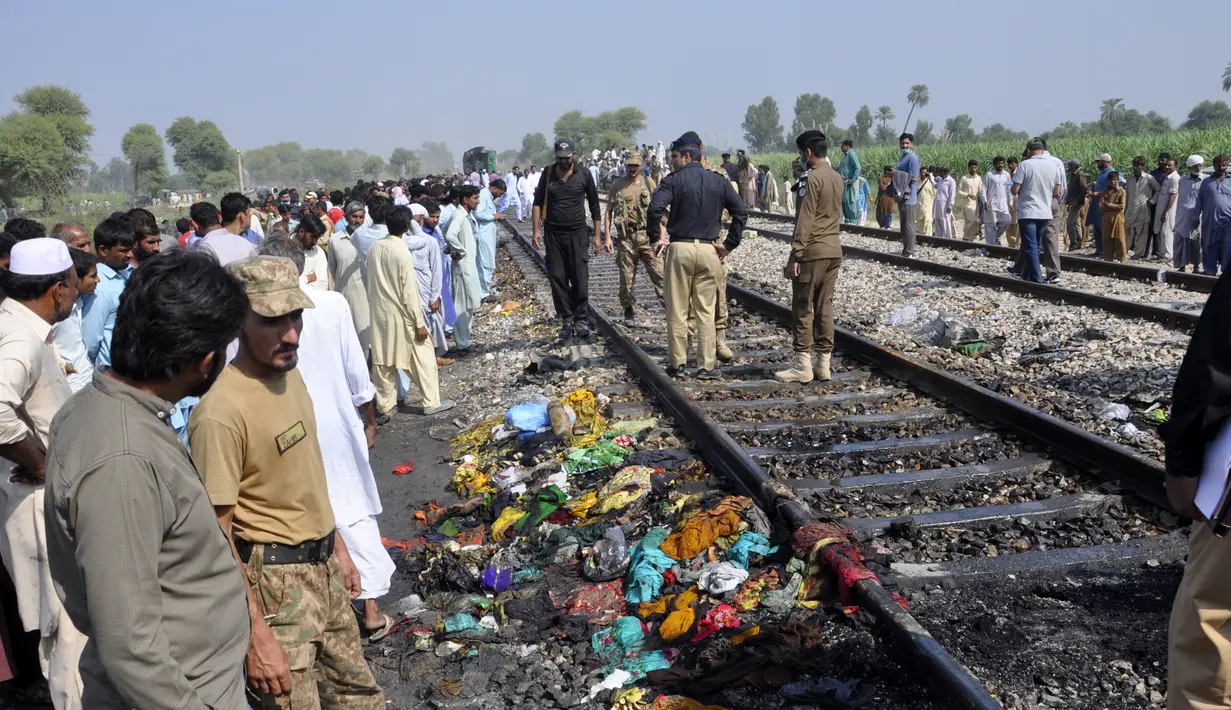 Tentara dan pejabat Pakistan memeriksa kereta yang rusak akibat kebakaran di Liaquatpur, Pakistan (31/10/2019). Insiden terjadi pada kereta yang dikenal sebagai Tezgam Espress. Kereta itu melakukan perjalanan ke berbagai kota antara daerah Karachi dan Rawalpindi.  (AP Photo/Siddique Baluch)