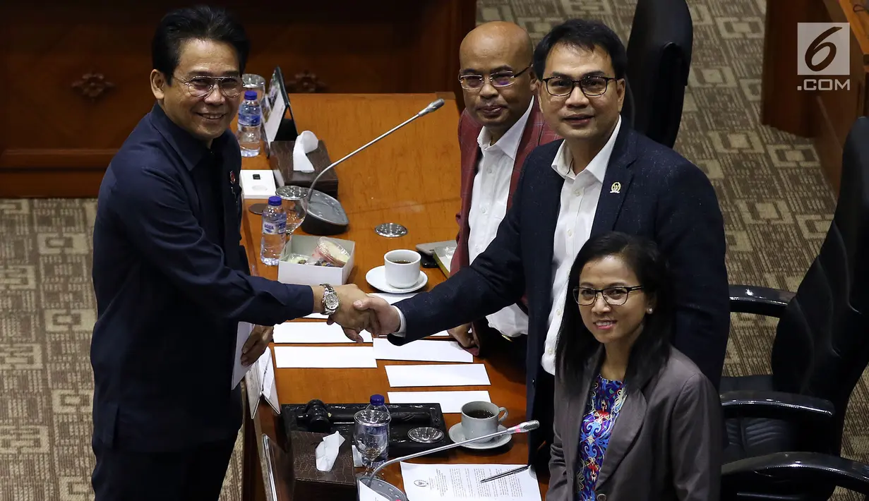 Calon Pimpinan KPK Johanis Tanak berjabat tangan dengan Ketua Komisi III DPR Aziz Syamsuddin (kanan) usai menerima amplop berisi tema makalah yang harus dibuat, saat uji kelayakan dan kepatutan capim KPK di Kompleks Parlemen, Senayan, Jakarta, Senin (9/9/2019). (Liputan6.com/Johan Tallo)
