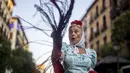 Seorang wanita mengenakan pakaian tradisional daerah Madrid dan dikenal sebagai 'Chulapa' menari selama perayaan San Cayetano, santo pelindung tenaga kerja dan roti, di lingkungan Lavapies di Madrid, Spanyol, Sabtu (6/8/2022). Festival San Cayetano menandai awal dari serangkaian festival populer di Madrid. (AP Photo/Manu Fernandez)