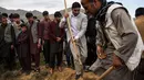 Teman dan kerabat memakamkan jenazah kepala fotografer AFP Afghanistan Shah Marai Faizi di Gul Dara, Kabul (30/4). Shah Marai merupakan korban ledakan di ibu kota Afghanistan, Kabul yang terjadi pada hari Senin (30/4). (Andrew Quilty / POOL / AFP)