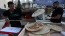 Penjual roti Palestina Mohammed Abu Saud (kiri) menyiapkan roti di Kota Nablus, Tepi Barat, (3/5/2020). Abu Saud, yang kehilangan pekerjaannya sebagai pekerja transportasi karena kebijakan lockdown selama pandemi COVID-19, memutuskan bekerja sebagai penjual roti keliling. (Xinhua/Ayman Nobani)