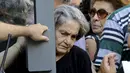 Seorang pensiunan wanita berusaha keluar dari pintu bank nasional usai mendapatkan uang pensiunannya di Iraklio, Yunani, (9/7/2015). Yunani dinyatakan bangkrut karena tidak sanggup membayar hutangnya 1,8 miliar dolar. (REUTERS/Stefanos Rapanis)