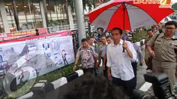 Jokowi menggunakan payung saat mengunjungi Terminal Manggarai, Jakarta, Rabu (16/04/2014) Warga menyambut kedatangan Jokowi dengan antusias (Liputan6.com/Herman Zakharia).