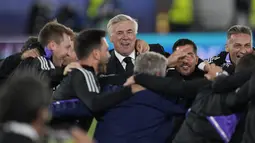 Pelatih Real Madrid, Carlo Ancelotti (tengah) merayakan dengan stafnya setelah memenangkan pertandingan melawan Eintracht Frankfurt pada final Piala Super Eropa di Stadion Olimpiade Helsinki, Finlandia, Kamis (11/8/2022). Real Madrid menang atas Eintracht Frankfurt 2-0. (AP Photo/Antonio Calanni)