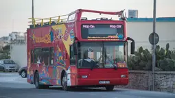 Kondisi sebuah bus wisata tingkat beratap terbuka yang menabrak dahan pohon di Zurrieq, Malta, Senin (9/4). Tim penyelamat harus menggunakan derek untuk mengangkat penumpang yang terluka dengan tandu dari atas dek. (AP Photo/Rene Rossignaud)