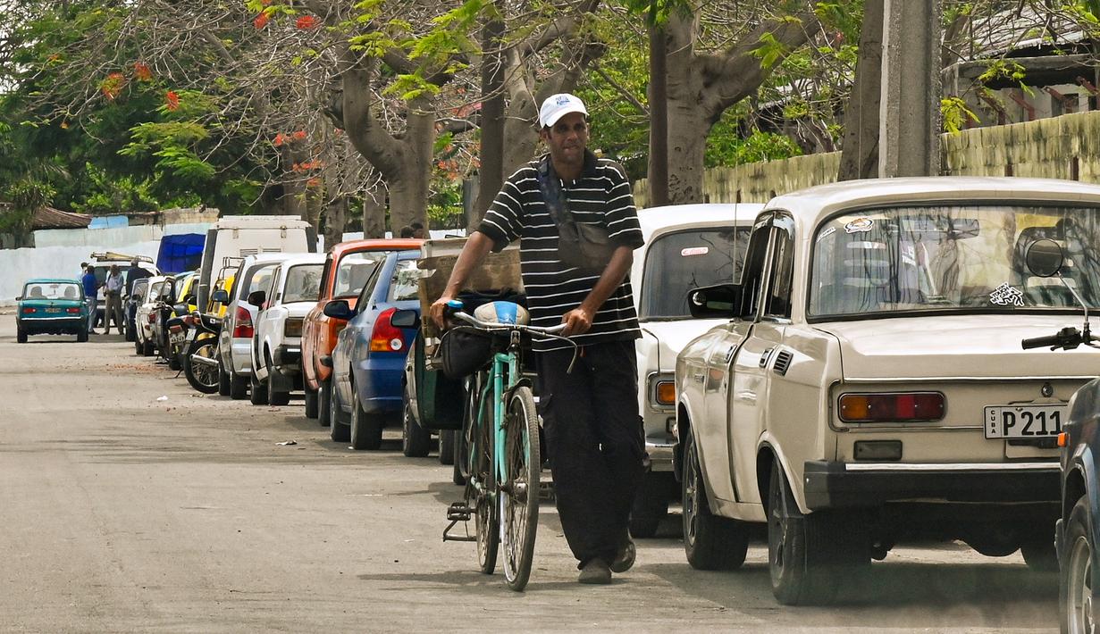 Di Havana, antrean panjangnya mencapai beberapa blok, dan penduduk bercanda bahwa bensin telah melarikan diri dari pulau itu dengan pembebasan bersyarat. (Photo by ADALBERTO ROQUE / AFP)