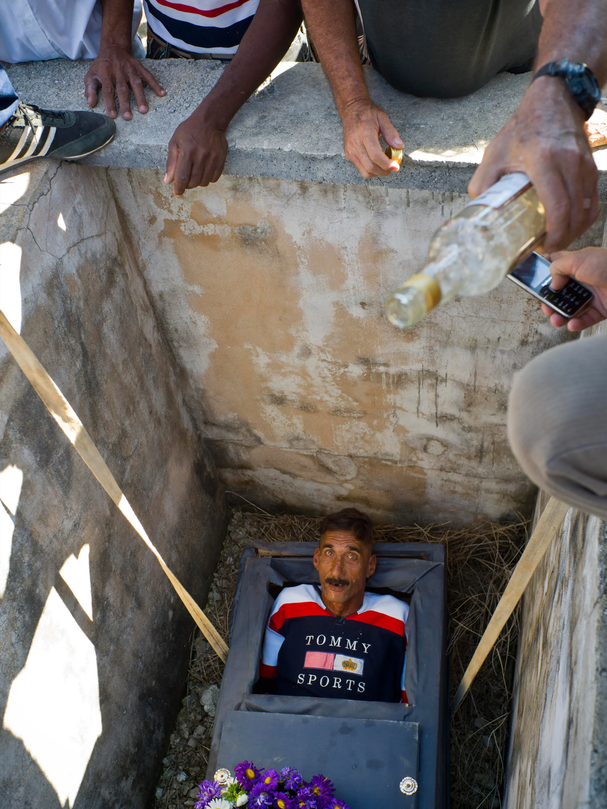 Divaldo Aguiar berbaring didalam peti matinya diturunkan ke dalam liang kubur saat festival Burial of Pachencho di Santiago de Las Vegas, Kuba (5/2). Asal nama “Pachencho” diambil dari judul kisah yang dimainkan teater setempat. (AP Photo/Ramon Espinosa)