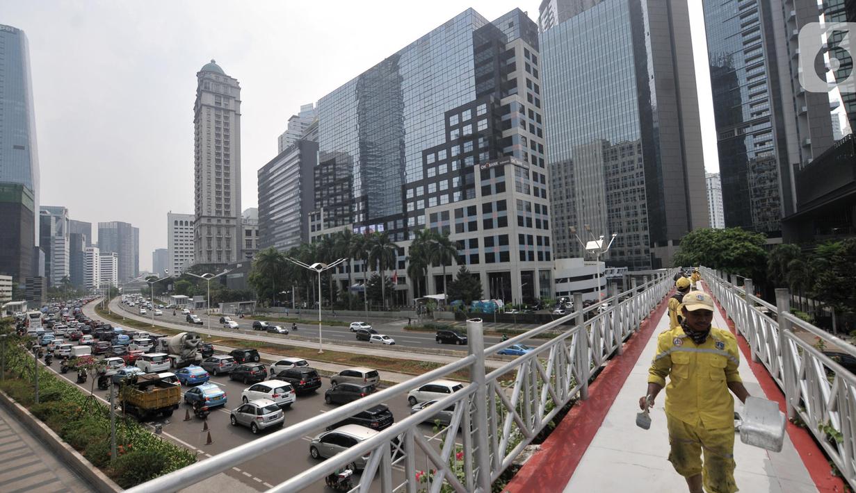 Petugas Bina Marga DKI Jakarta mengecat jembatan penyeberangan orang (JPO) yang tidak beratap di jalan Sudirman, Rabu (6/11/2019). Pemprov DKI melalui Dinas Bina Marga mencopot atap JPO Sudirman agar pejalan kaki dapat menikmati pemandangan gedung-gedung pencakar langit. (merdeka.com/Iqbal Nugroho)