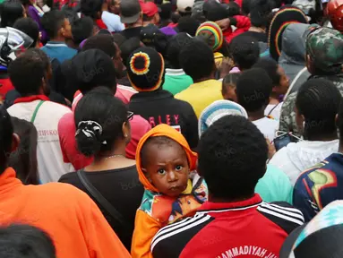 Suporter cilik ikut dalam antrean saat memasuki  areal stadion pada pembukaan Torabika Soccer Championship 2016 di Stadion Mandala, Jayapura, Papua, Jumat (29/4/2016). (Bola.com/Nicklas Hanoatubun)