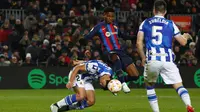 Ansu Fati dari Barcelona (tengah) berebut bola dengan pemain Real Sociedad Robin Le Normand pada pertandingan perempatfinal Copa del Rey di stadion Camp Nou, di Barcelona, Spanyol, Kamis (26/1/2023). Kemenangan ini mengantar Barcelona melaju ke semifinal. (AP Photo/Joan Monfort)