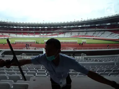 Pekerja membersihkan kaca tribun VIP di Stadion Gelora Bung Karno, Jakarta, Jumat (12/1). Rencananya, Stadion GBK akan diresmikan penggunaannya pasca renovasi oleh Presiden Joko Widodo, Minggu (14/1). (Liputan6.com/Helmi Fithriansyah)