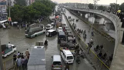 Para pengendara melewati jalan yang banjir di Karachi, Pakistan, Kamis (23/9/2021). Banjir merendam Karachi setelah diguyur hujan deras. (AP Photo/Fareed Khan)
