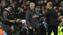 Pelatih Josep Guardiola berusaha merangkul pelatih Jose Mourinho selama pertandingan antara Manchester City melawan Manchester United di Liga Inggris di stadion Etihad, Inggris, (27/4). (AFP Photo/Oli Scarff)