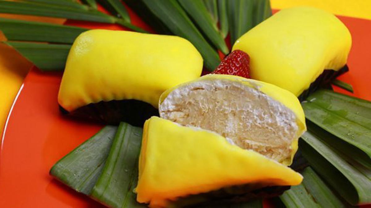 Pancake durian lembut berwarna hijau pastel, diisi dengan durian creamy dan whipped cream, siap memanjakan selera Anda