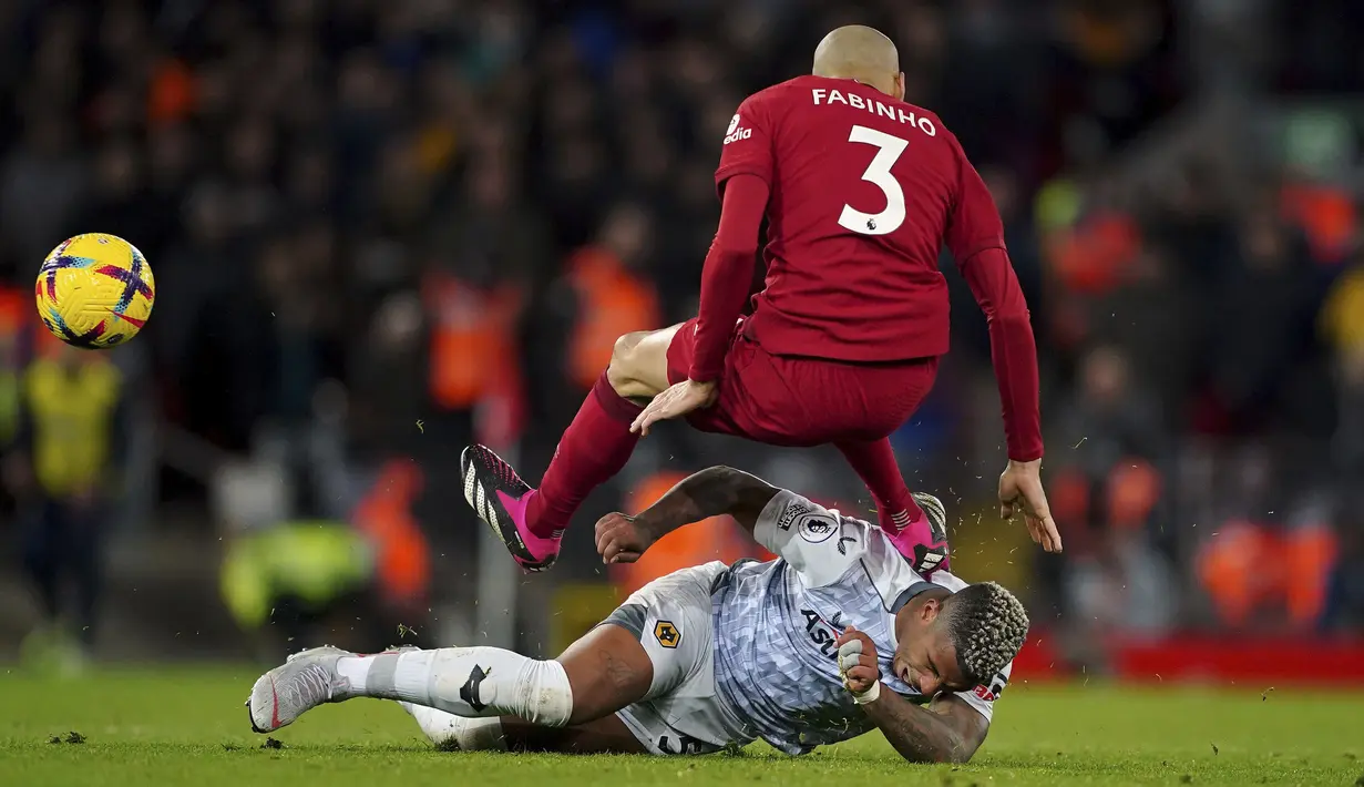 Gelandang Liverpool Fabinho berebut bola dengan gelandang Wolverhampton Wanderers Mario Lemina mengakibatkan kartu kuning pada laga tunda Liga Inggris pekan ke-7 di Anfield, Rabu (2/3/2023) dini hari WIB. Liverpool kini ada di urutan keenam dengan raihan 39 poin hasil dari 24 pertandingan. (Peter Byrne/PA via AP)