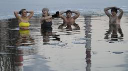 Orang-orang berenang di danau dengan suhu di bawah titik beku di Warsawa, Polandia (26/12/2021). Iklim di Polandia pada musim dingin yang sangat dingin, seringkali di bawah titik beku (0 °C atau 32 °F), dan musim panas yang hangat.  (AP Photo/Czarek Sokolowski)