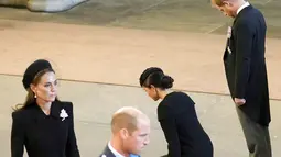 Meghan Markle dan Pangeran Harry memberikan penghormatan dalam prosesi persemayaman Ratu Elizabeth II di Westminster Hall, 14 September 2022. (Foto: Christopher Furlong/Pool Photo via AP)