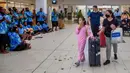 Wisatawan disambut oleh kelompok budaya tradisional di Nadi, Fiji, Rabu (1/12/2021). Fiji membuka perbatasannya untuk pelancong internasional pertama kalinya sejak pandemi Covid-19 melanda dunia dan menghancurkan ekonominya yang bergantung pada pariwisata. (Leon LORD/AFP)