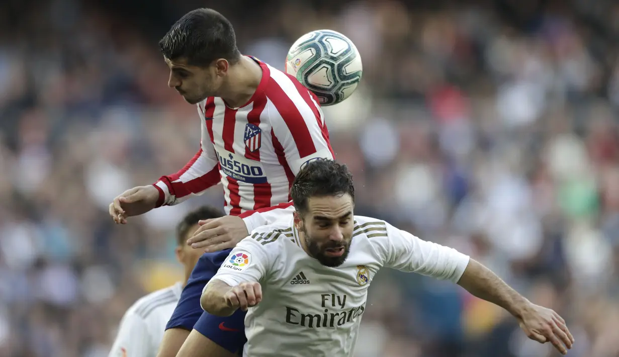 Penyerang Atletico Madrid, Alvaro Morata berebut bola dengan bek Real Madrid, Dani Carvajal pada pertandingan lanjutan La Liga Spanyol di stadion Santiago Bernabeu di Madrid, Sabtu, (1/2/2020). Real Madrid menang tipis 1-0 atas Atletico Madrid. (AP Photo/Bernat Armangue)