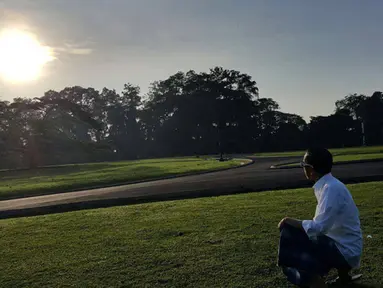 Presiden Jokowi menyaksikan keindahan fenomena Gerhana Matahari di halaman Istana Bogor, Rabu (9/3). Dengan peenampilan yang santai memakai sarung Jokowi tampak menikmati keindahan fenomena alam yang luar biasa tersebut. (facebook.com/Jokowi)