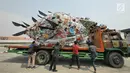 Aktivis pemerhati lingkungan menurunkan monster plastik dari atas truk saat aksi Tolak Penggunaan Plastik Sekali Pakai di Pelabuhan Sunda Kelapa, Jakarta, Sabtu (20/7/2019). Monster plastik itu berupa rangka berbentuk ikan anglerfish yang ukurannya sebesar mobil sampah (Liputan6.com/Herman Zakharia)