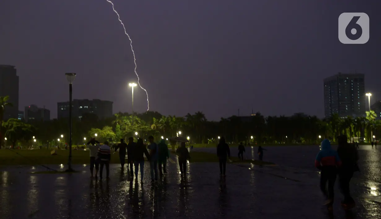 Kilatan petir menyambar di kawasan Monas, saat hujan yang disertai angin mengguyur Jakarta, Sabtu (21/12/2019),Malam. BMKG mengingatkan agar waspada terhadap potensi hujan deras yang disertai petir diprediksi akan terjadi dalam beberapa hari kedepan. (merdeka.com/Imam Buhori)