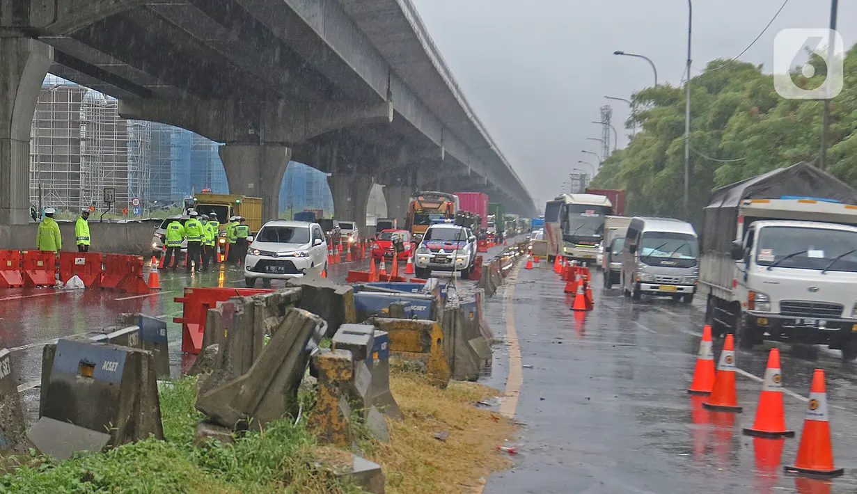 Petugas kepolisian berjaga di Pos Penyekatan Jalur Mudik di Gerbang Tol Cikarang Barat, Kabupaten Bekasi, Senin (18/5). Memasuki H-6 Lebaran, puluhan kendaraan diminta untuk putar balik karena melanggar larangan mudik sebagai upaya memutus rantai penyebaran Covid-19. (Liputan6.com/Herman Zakharia)