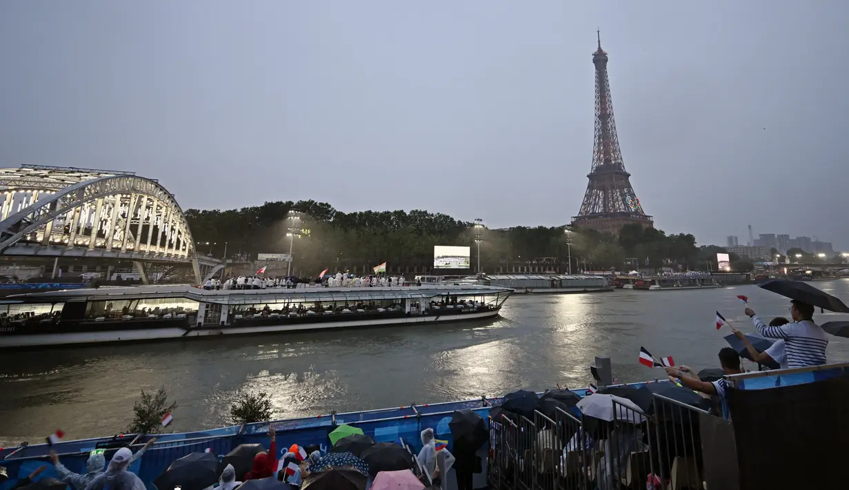 Sebanyak 205 kontingen dari negara peserta mengikuti defile pembukaan Olimpiade Paris 2024 dengan menggunakan 85 kapal menyusuri sungai Seine sejauh 6 km dari jembatan Austerlitz menuju Trocadero, dekat Menara Eiffel. (Manan VATSYAYANA / AFP)