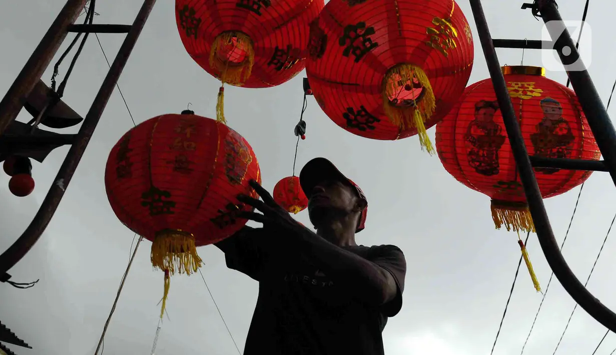 Pekerja memasang lampion di halaman Klenteng Hok Lay Kiong, Kelurahan Margahayu, Bekasi, Jawa Barat, Jumat (13/1/2023). Pemasangan ratusan lampion dari pintu masuk hingga bagian dalam klenteng itu untuk menyambut Tahun Baru Imlek 2574 yang akan jatuh pada 22 Januari 2023 mendatang. (merdeka.com/Imam Buhori)