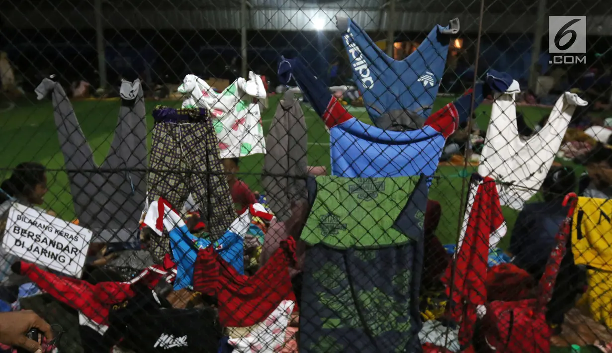 Pakaian anak-anak korban Tsunami Anyer tampak dijemur di lapangan futsal Labuan, Banten, Minggu (23/12). Warga memilih mengungsi menunggu suasana di pesisir Pantai Selat Sunda pulih dan kondusif. (Liputan6.com/Angga Yuniar)