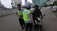 Aparat kepolisian lalu lintas saat memberhentikan pengendara motor gede yang menerobos Jalan MH Thamrin, Jakarta, Minggu (18/1/2015). (Liputan6.com/Miftahul Hayat)