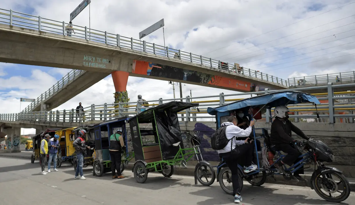 Orang-orang menggunakan menggunakan bicitaxis sebagai alternatif transportasi setelah penghancuran beberapa stasiun layanan publik selama protes terhadap pemerintah Presiden Kolombia Ivan Duque, di Bogota (24/5/2021). (AFP/ Raul Arboleda)