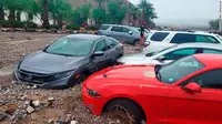 Mobil terlihat terjebak dalam lumpur dan puing-puing di The Inn at Death Valley pada 5 Agustus 2022. Banjir langka di tempat terpanas Bumi. (National Park Service/AP)