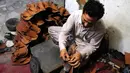 Seorang pembuat sepatu asal Pakistan membuat sepatu tradisional yang dikenal sebagai "chapli" di kalangan penduduk lokal untuk menyambut Hari Raya Idul Fitri di Peshawar, Pakistan barat laut, pada 19 Mei 2020. (Xinhua/Saeed Ahmad)