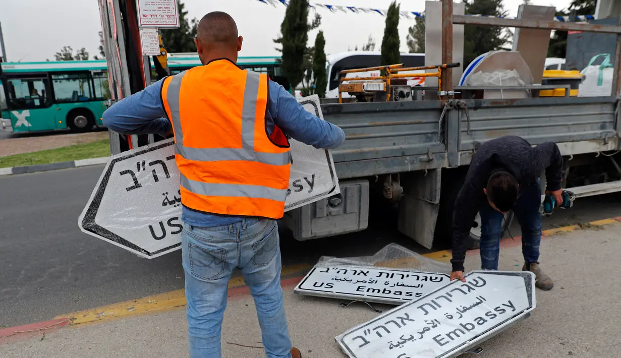 Pekerja memasang papan penunjuk jalan menuju Kedutaan Besar Amerika Serikat (AS) di Yerusalem, Senin (7/5). Seremoni pemindahan kedubes AS untuk Israel dari Tel Aviv ke Yerusalem dijadwalkan dilangsungkan pada 14 Mei mendatang. (AFP/THOMAS COEX)