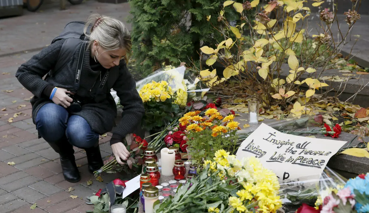 Seorang wanita menaruh bunga di dekat Kedutaan Besar Prancis untuk memperingati korban serangan di Paris, di Kiev, Ukraina, (14/11/2015). Serangan teroris yang terjadi di Paris telah menewaskan sekitar 140 orang. (REUTERS/Valentyn Ogirenko)
