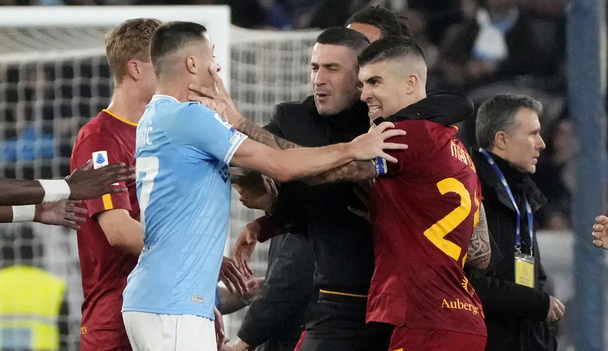 Pemain Lazio, Adam Marusic, bersitegang dengan pemain  AS Roma, Gianluca Mancini, pada laga pekan ke-27 Serie A 2022/2023 di Stadion Olimpico, Senin (20/03/2023). Total ada tiga kartu merah dikeluarkan wasit di laga panas ini. (AP Photo/Gregorio Borgia)