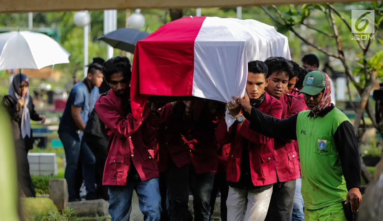 Sejumlah mahasiswa mengangkat peti jenazah Benny Soemarno saat akan dimakamkan di TPU Karet Bivak, Jakarta, Senin (2/4). Benny Soemarno meninggal pada usia 68 tahun. (Liputan6.com/Faizal Fanani)