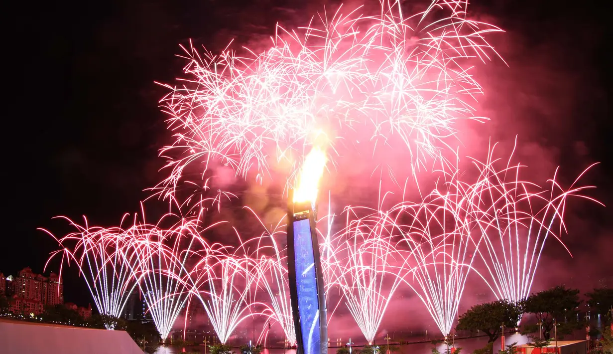 Pesta kembang api yang menjadi latar kaldron api SEA Games menghiasi langit Singapura pada saat Pembukaan SEA Games 2015 di Stadion Nasional Singapura. Jumat (5/6). (Bola.com/Arief Bagus)