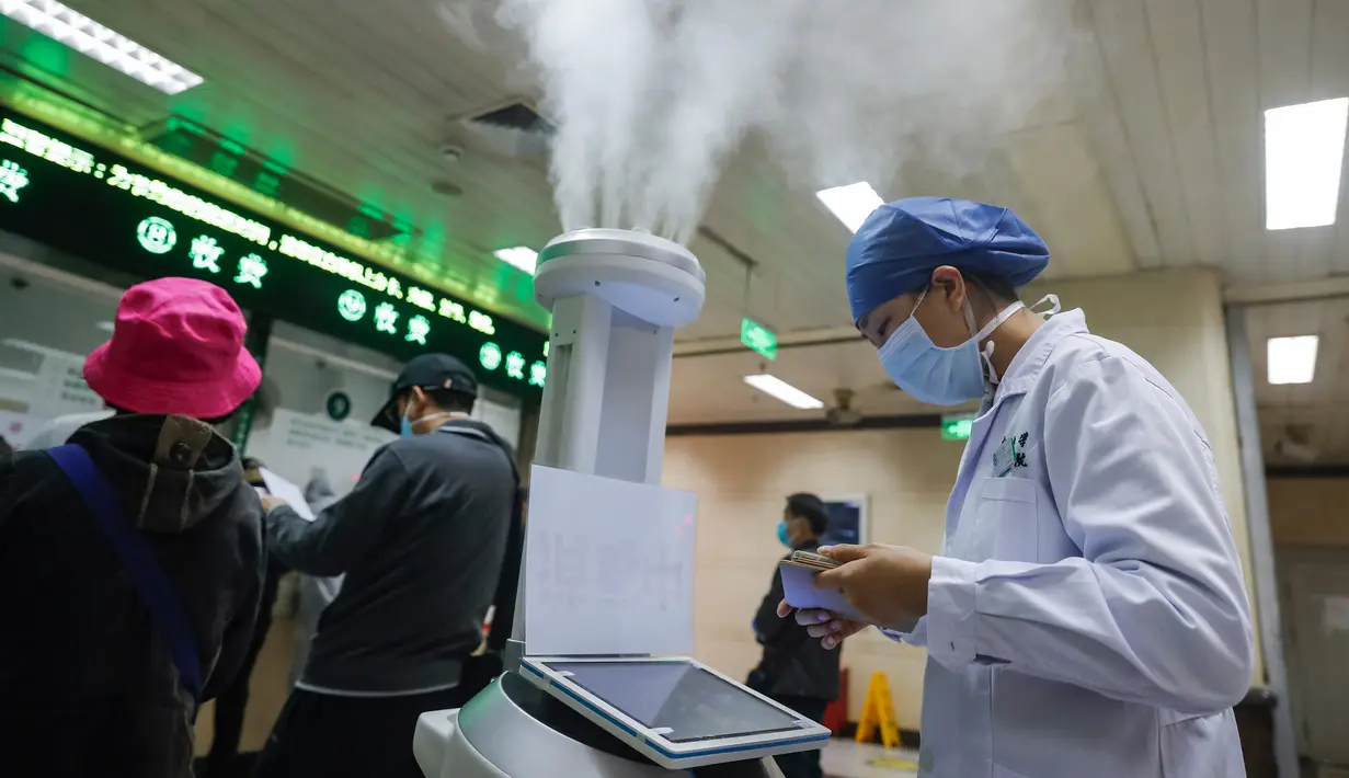 Staf medis menggunakan komputer tablet untuk mengendalikan robot pintar di ruang rawat jalan Rumah Sakit Renmin Universitas Wuhan di Wuhan, 16 Maret 2020. Robot pintar itu mampu melakukan pekerjaan disinfeksi secara otomatis di sejumlah lokasi yang telah ditentukan satu per satu. (Xinhua/Shen Bohan)
