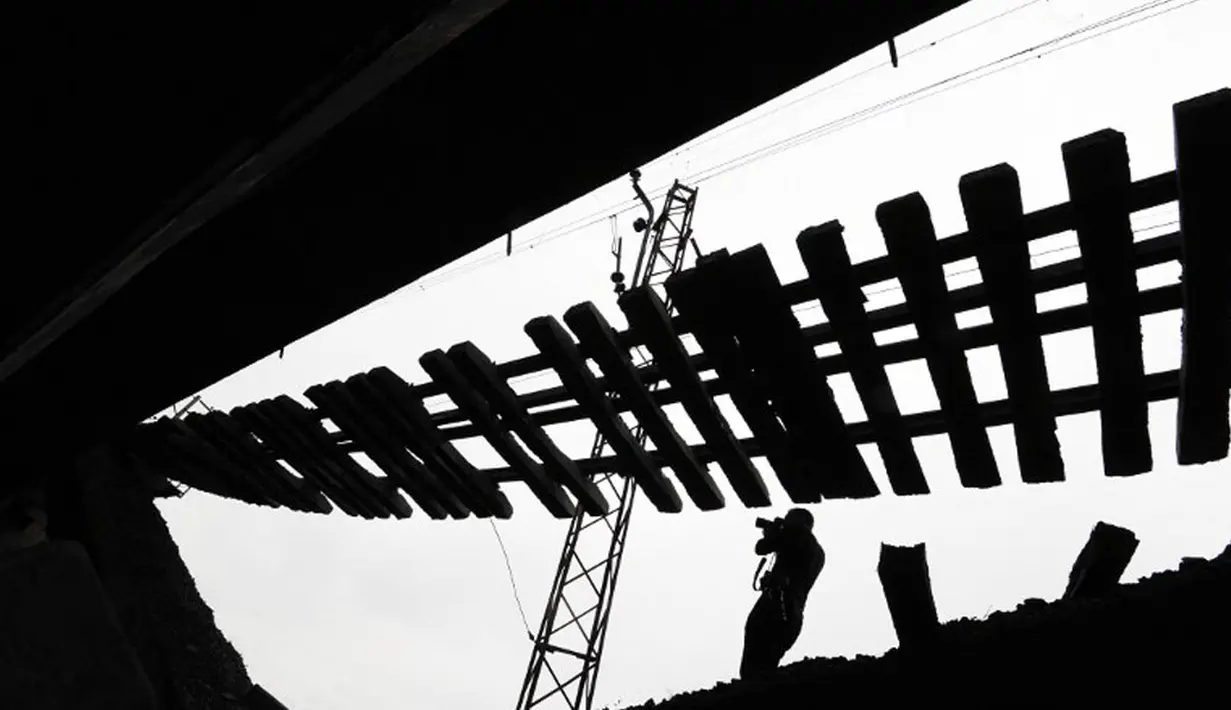 Salah satu fotografer memotret kondisi jembatan kereta yang runtuh di dekat desa Novobakhmutivka, 30 km sebelah utara Donetsk, Ukraina, (8/7/2014). (AFP PHOTO/Dominique Faget)